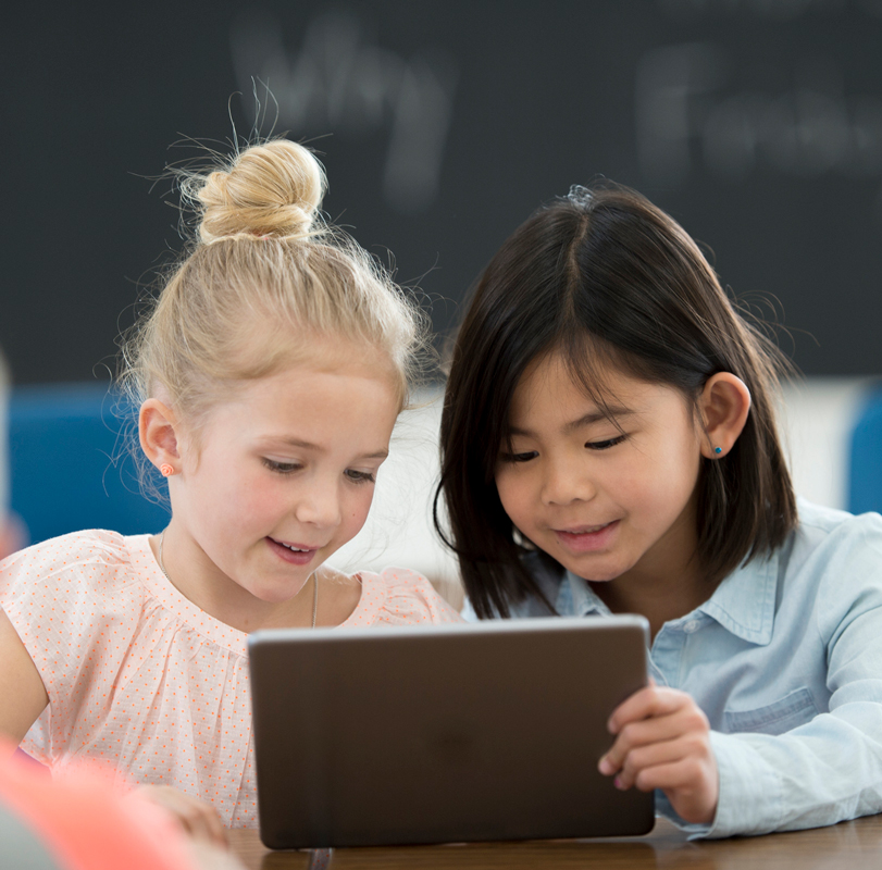 两个幼儿园的孩子在玩平板电脑