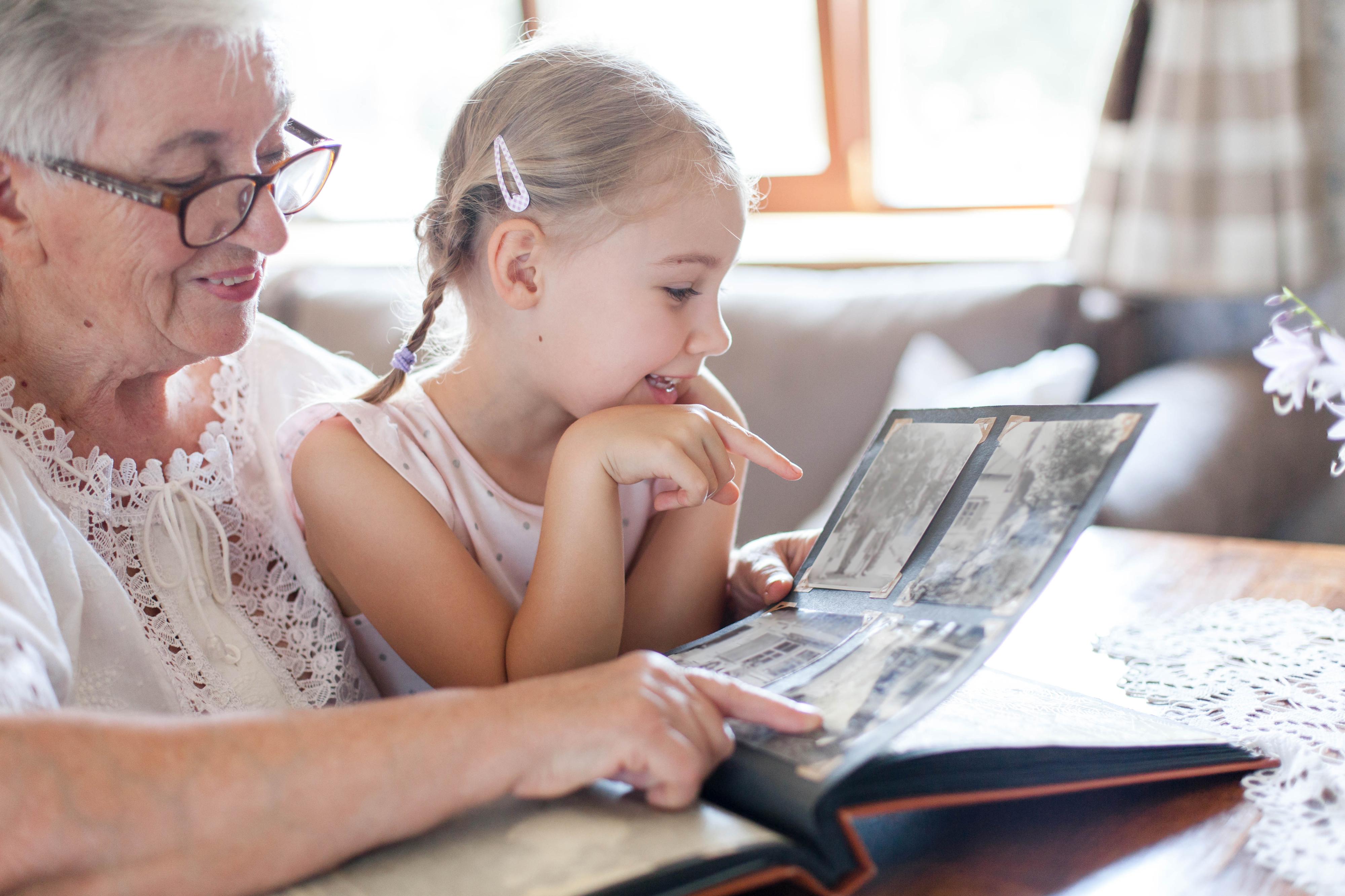 一个孩子和她的祖母在看剪贴簿。