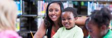 女人和儿子坐在图书馆里微笑。