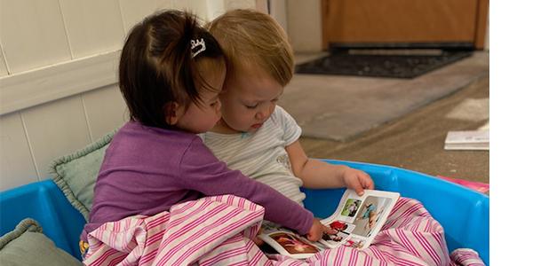 两个婴儿在看一本书