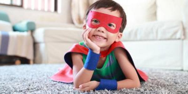 一个穿着超级英雄斗篷和面具的学龄前男孩