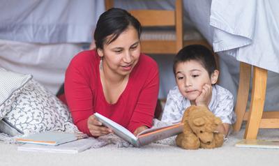 母亲和儿子在孩子房间的地板上看书