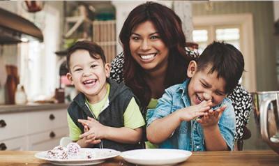 母亲和两个儿子坐在厨房的桌子旁笑
