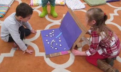 两个孩子正在用纸板箱做一个项目