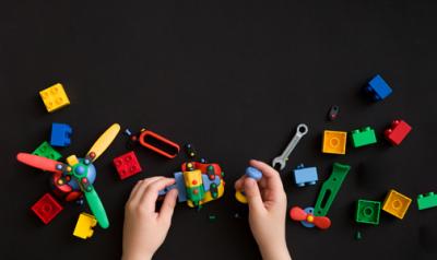一个孩子的手在玩各种各样的玩具