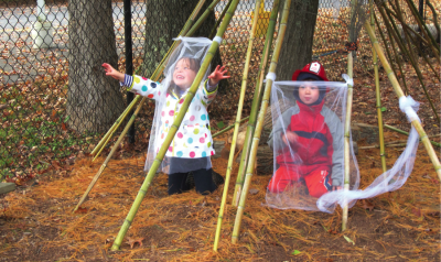 两个孩子在外面的长竹竿下玩耍