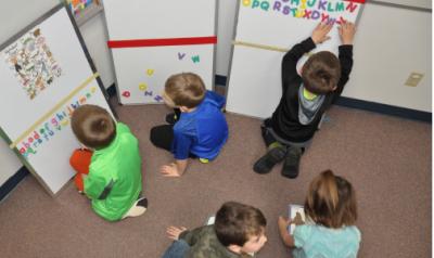 五个幼儿园男孩在教室里玩学习工具