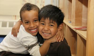 两个年轻的有色人种男孩拥抱着，小进了镜头。