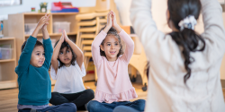 儿童和一名教师做瑜伽姿势