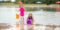 两个年轻的女孩在湖边捞水变成水桶