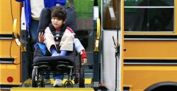 一个坐在轮椅上的孩子从公共汽车上下来