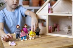 一个孩子在玩偶屋玩玩偶