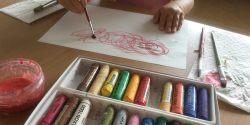 一个孩子在用美术用品和颜料